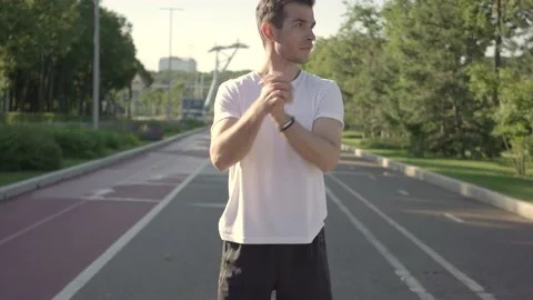 Fit young man preparing for workout doing stretching exercise for arms Stock Footage 146307762