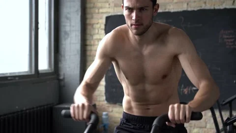 Fit young man using exercise bike at the gym Stock Footage 131218153