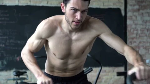 Fit young man using exercise bike at the gym Stock Footage 131218173