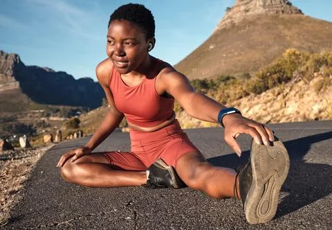 Fitness, black woman and stretching legs on mountain, urban road and Cape Town Stock Photos