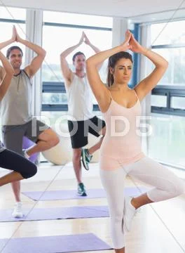 Fitness class and instructor standing in tree pose Stock Photos