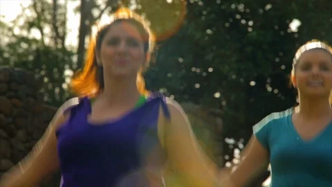 Fitness class doing jumping jacks in park. Видео 88407367