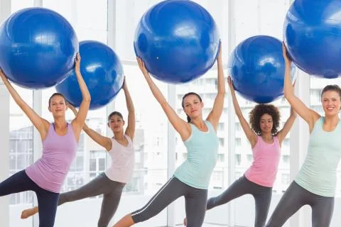 Fitness class doing pilates exercise with fitness balls Stock Photos