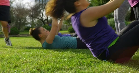 Fitness class doing sit-ups in park. Video stock 88376733
