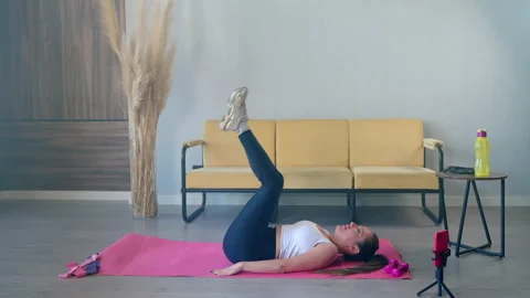 Fitness coach is doing physical exercise at home and streaming in social network Stock Footage 165300345