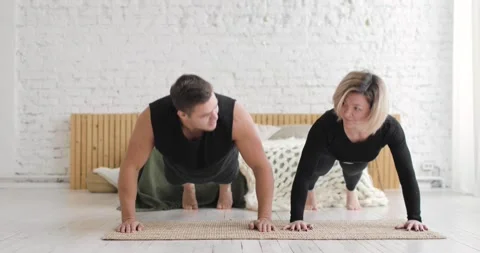Fitness couple doing push up exercises together on workout at home, front view. Stock Footage 146679512