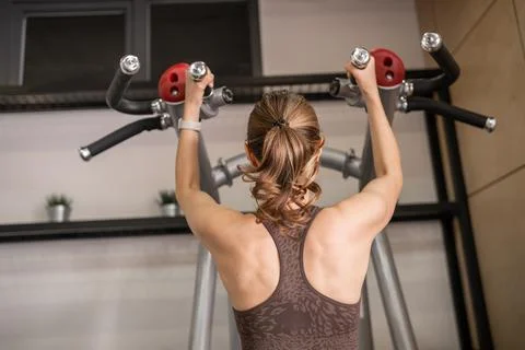 Fitness Enthusiast Practicing Pull-Ups in a Modern Gym Setting During Afternoon Stock Photos