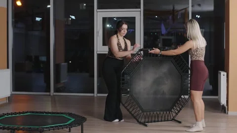 Fitness enthusiasts demonstrating trampoline setup and stretching exercises Video stock 321751993