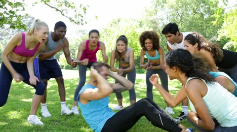 Fitness group cheering on man doing sit ... | Stock Video | Pond5