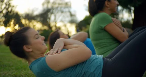 Fitness group doing sit-ups in park. Stock Footage 88376894