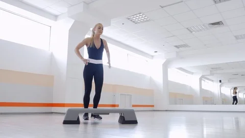 Fitness instructor doing basic aerobics steps in gym Video stock 86220080