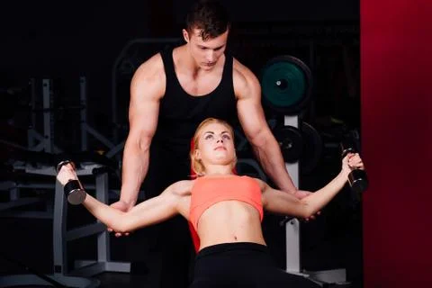 Fitness instructor exercising with his client at the gym Stock Photos