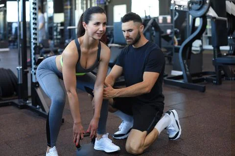 Fitness instructor exercising with his client at the gym. Stock Photos