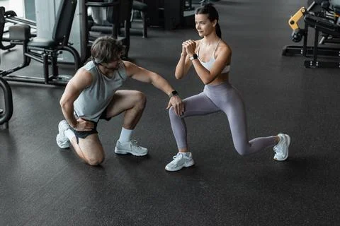 Fitness instructor exercising with his client at the gym. Stock Photos