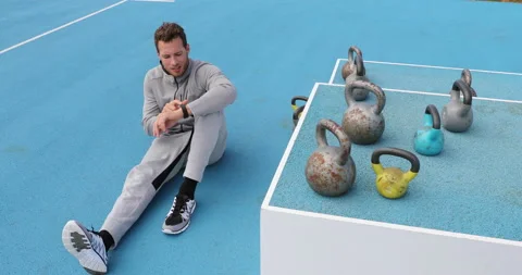 Fitness man checking smartwatch during workout strength training at Stock Footage 168449166