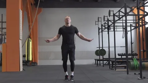Fitness man doing double jumps rope exercise in gym Stock Footage 88692380