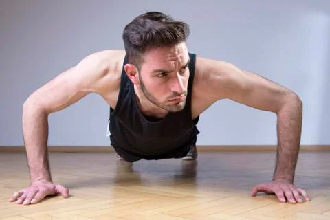 Fitness man doing push ups on a floor Stock Photos
