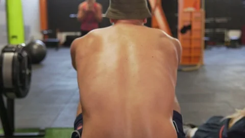Fitness man doing rowing workout in gym, back view Stock Footage 90467314