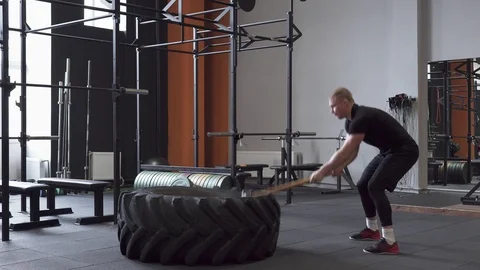 Fitness man doing sledgehammer swing exercise in gym Stock Footage 88691875