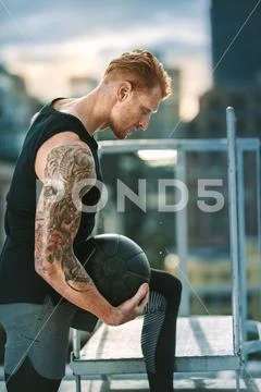 Fitness man doing workout on rooftop using a medicine ball Stock Photos