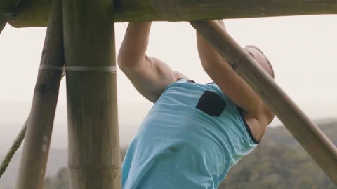 Fitness man training pulling up exercise on horizontal bar in tropical highlands Stock Footage 107137451