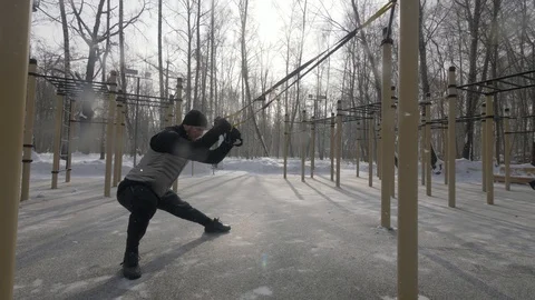 Fitness man using trx loop equipment for training on outdoor sport ground Stock Footage 88176745