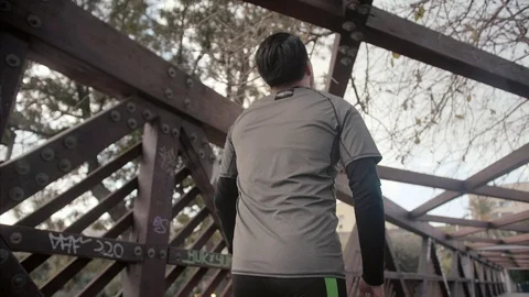Fitness man working out doing pull-ups on a wooden bridge outdoor urban Video stock 104489790