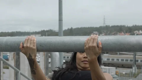 Fitness model doing back exercise on fence Stock Footage 113742525