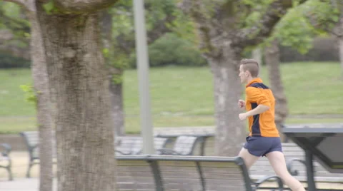 Fitness Model Jogs Through Beautiful City Park, Shot With A Long Lens In 4K Stock Footage 50009635