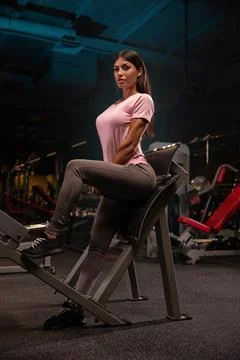 Fitness model performs strength training on bench in gym showcasing her athletic Stock Photos