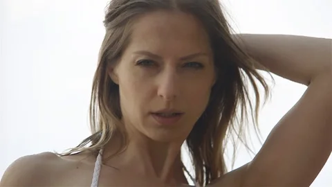 Fitness model posing under the rain on the sea beach Video stock 100280140