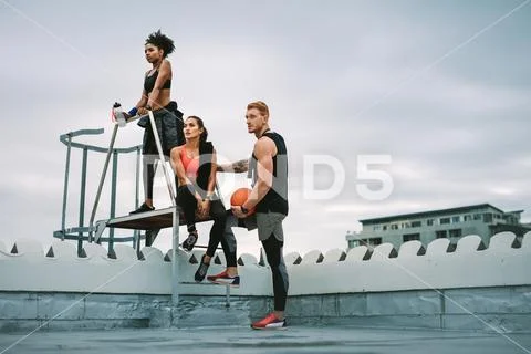 Fitness people taking a break from workout standing on rooftop Stock Photos