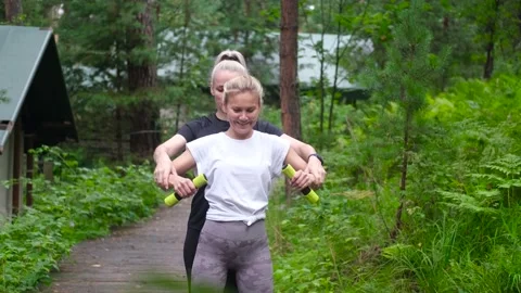 Fitness. Personal trainer taking notes while woman exercising outdoors. Two Stock Footage 234200580
