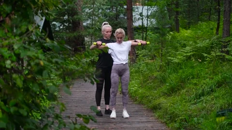 Fitness. Personal trainer taking notes while woman exercising outdoors. Two Stock Footage 234205888
