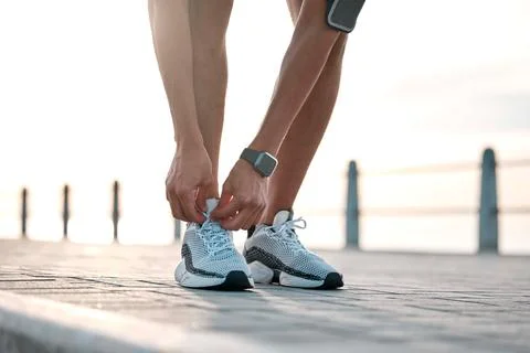 Fitness, running and man tie shoes by ocean ready for exercise, marathon Stock Photos
