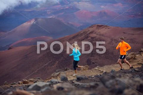 Fitness sport couple running jogging outside on trail Stock Photos