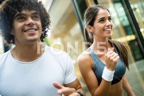 Fitness, sport, friendship and lifestyle concept - smiling couple running Stock Photos