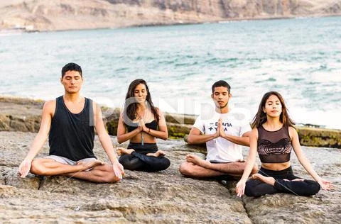 Fitness, sport, yoga and healthy lifestyle concept - group of people meditating Stock Photos