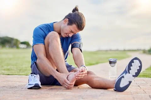 Fitness, sports injury and foot pain with man in park for muscle spasm Stock Photos