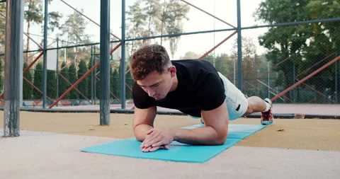 Fitness Strength Training Practicing Plank Exercise in an Inviting Outdoor Stock Footage 317979607