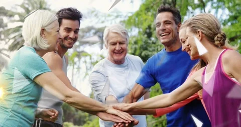 Fitness team stacking hands and breaking huddle in park, cheering, starting 動画素材 330159798