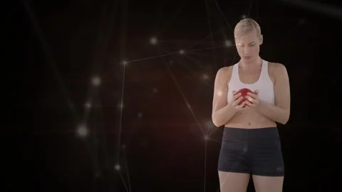 Fitness trainer lifting gaze, network nodes brightening, raising red med ball to Stock Footage 330917876
