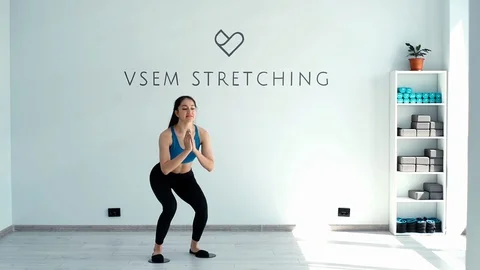 Fitness trainer smiling and doing squats with gliding discs in slow motion Stock Footage 112022588