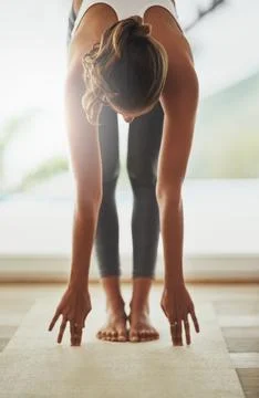 Fitness is a way of life. Full length shot of a young woman practicing yoga at Stock Photos