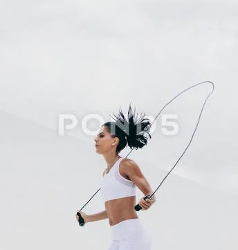 Fitness woman doing workout using a skipping rope Stock Photos