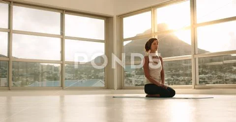 Fitness woman sitting in yoga pose at gym Stock Photos