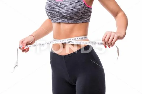 Photograph: Fitness Woman in sport bra measuring her body with