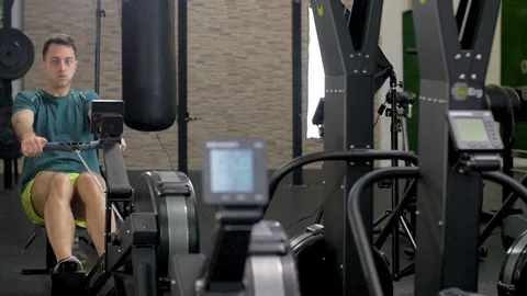 Fitness young man using rowing machine in the gym Stock Footage 112718708