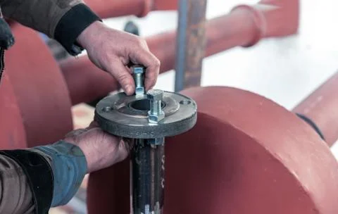 Fitter assembler is assembling a new gas pipeline line in a gas boiler room. Stock Photos