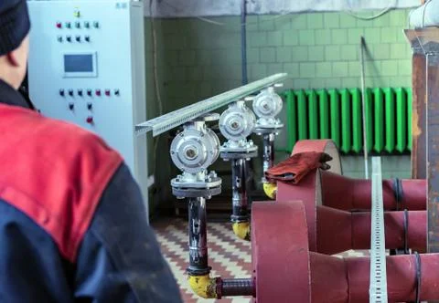 Fitter assembler is assembling a new gas pipeline line in a gas boiler room. Stock Photos